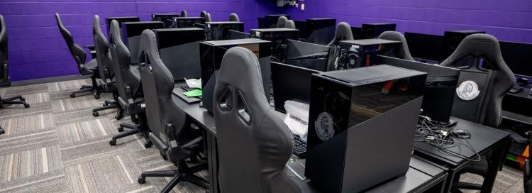 A large room featuring several computer desks and chairs, designed for group work and individual study sessions.
