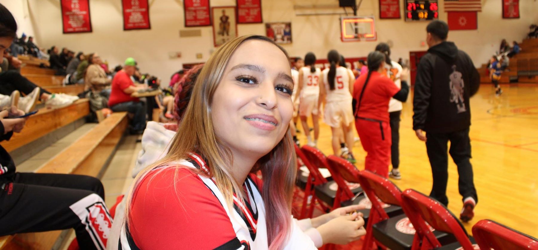 female student in bleachers watching a game